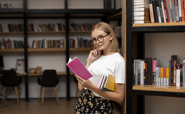 jovem na biblioteca com uma estante para livros ao fundo